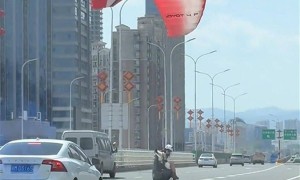 南昌一女子搭降落伞空降桥面，过往车辆紧急避让，目击者：桥下就是赣江